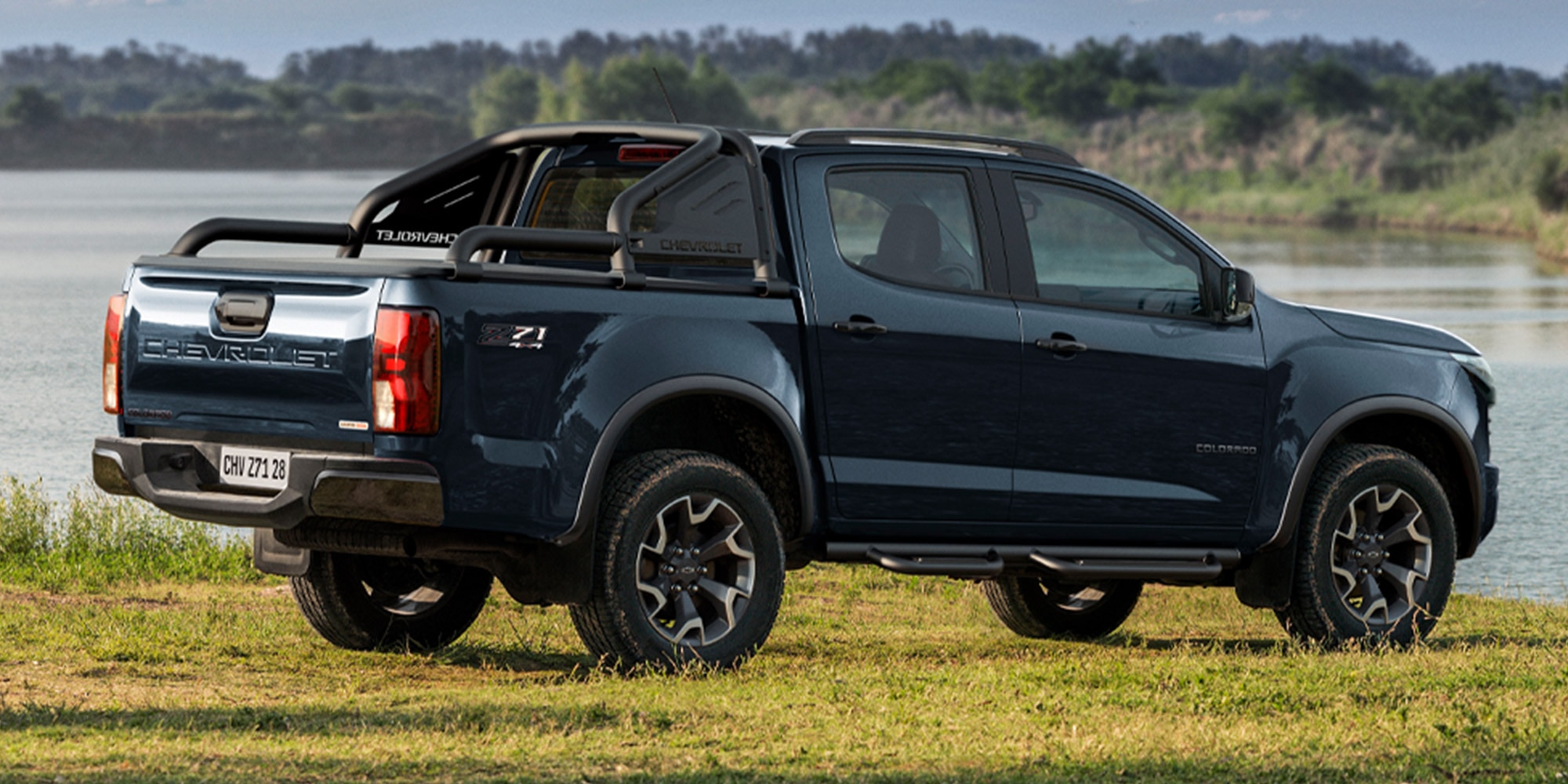 Chevrolet Colorado Verde Musgo parqueada sobre pasto junto a un lago resaltando su diseño pickup